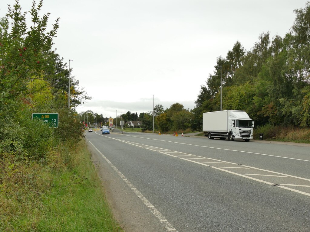 The A65 at the western end of the Burley bypass, a wide road with a lorry and a road sign for Skipton